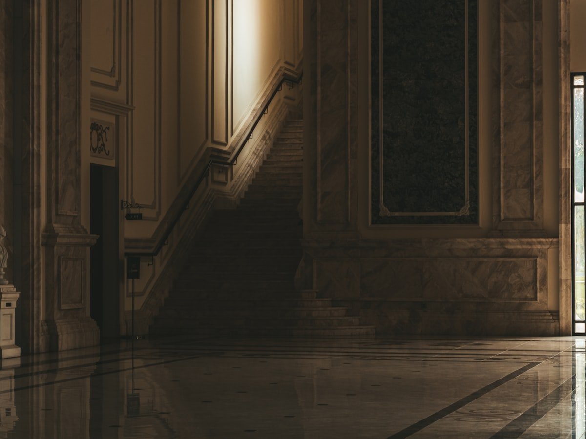 A grand marble hall with a staircase ascending toward the light — the path inside